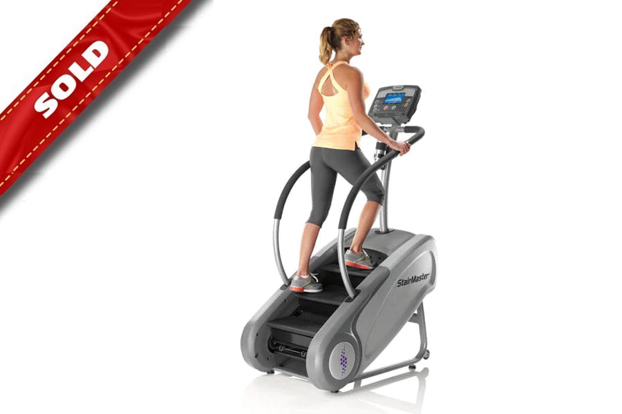 Woman wearing yellow tank top and black capris exercising on StairMaster SM3 StepMill with digital display console