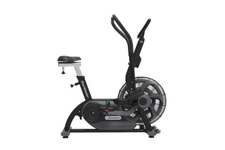 Black upright stationary bike with dual handles, fan wheel, and padded seat on white background