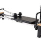 Stamina Pilates Reformer with black metal frame, wooden footbar and platform, padded black carriage, and adjustable resistanc