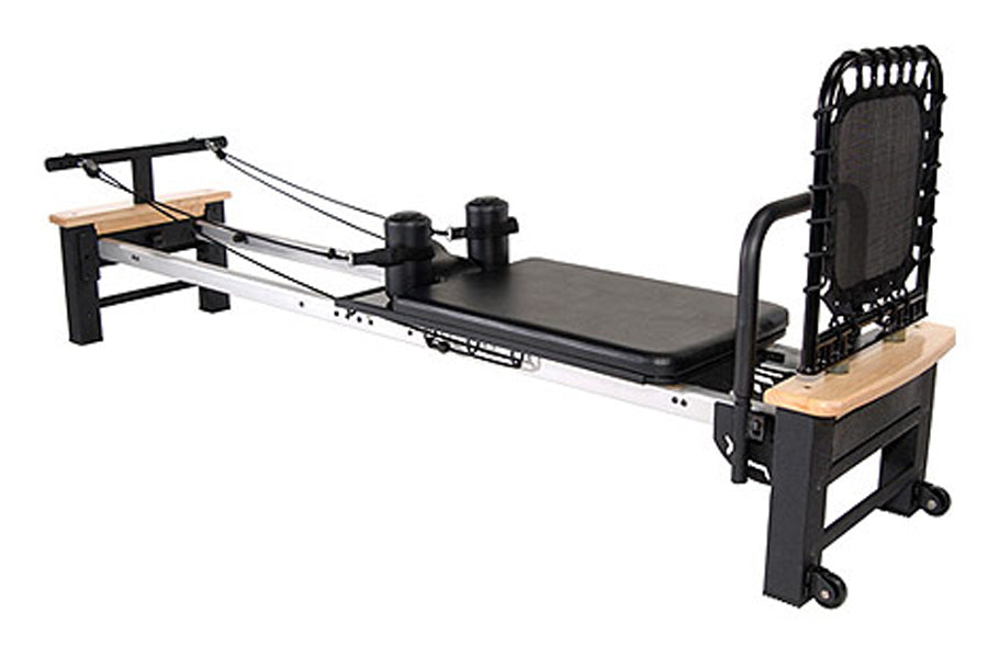 Stamina Pilates Reformer with black metal frame, wooden footbar and platform, padded black carriage, and adjustable resistanc