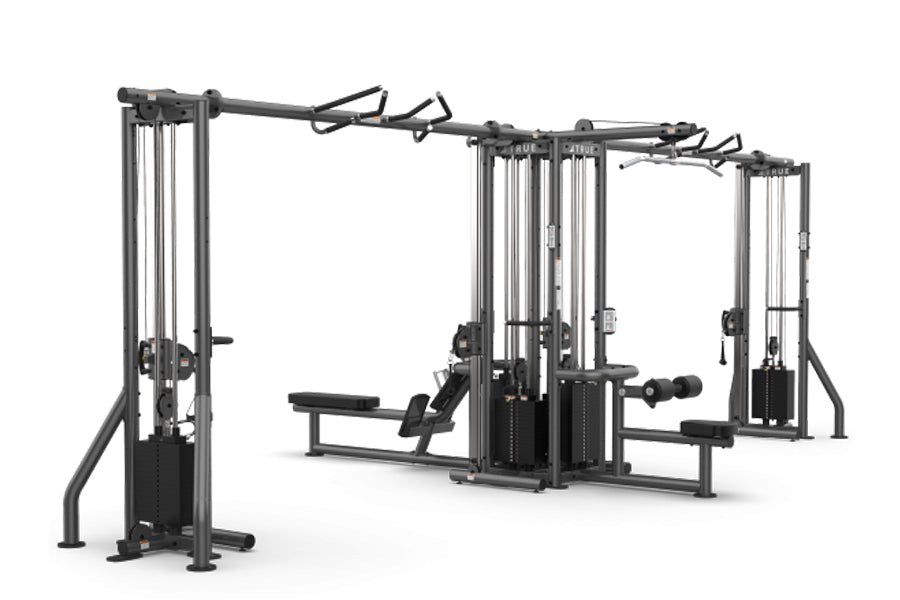 TRUE TMS6000 modular multi-station gym frame with dual cable crossovers and weight stacks, black metal construction on white 