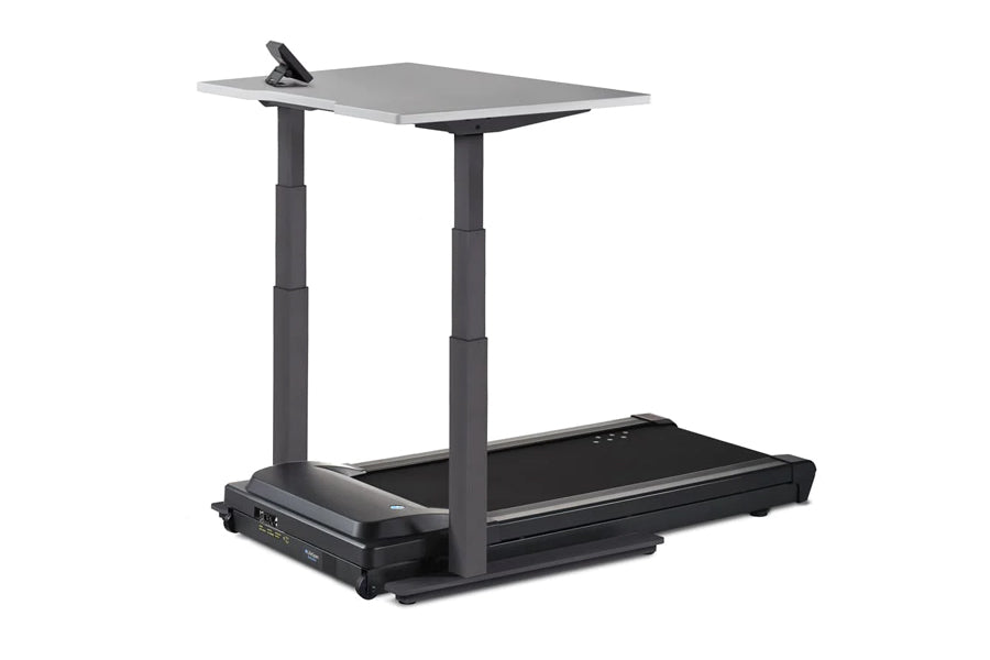 Black and gray standing desk treadmill with gray work surface, adjustable height columns, and black treadmill base on white b