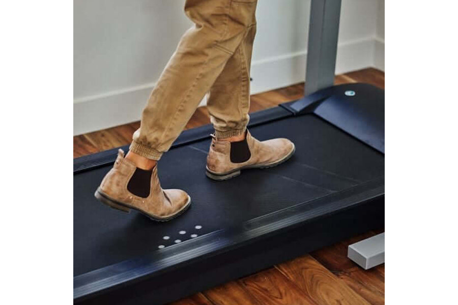 Tan suede Chelsea boots with elastic side panels worn by model on LifeSpan treadmill desk