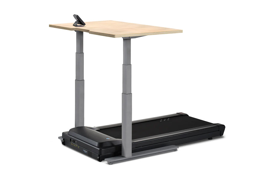 Height-adjustable desk treadmill with light wood top, gray steel frame, and black motorized treadmill base on white backgroun