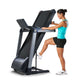 LifeSpan TR3000i black folding treadmill with dual display screens, woman in turquoise tank top using it