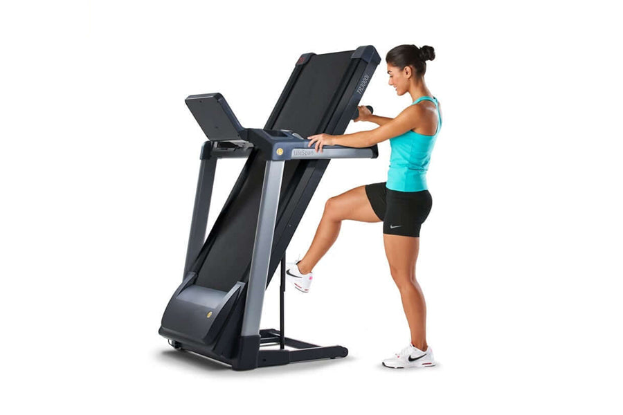 LifeSpan TR3000i black folding treadmill with dual display screens, woman in turquoise tank top using it