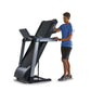 Man in blue shirt using black and gray folding treadmill with digital display on white background