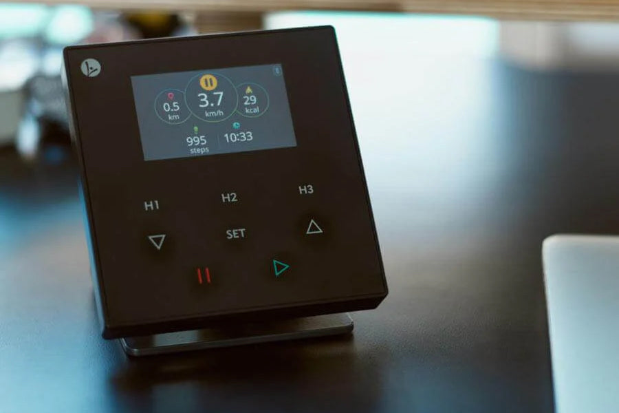 Black fitness tracker device with LCD screen displaying distance, speed, steps, calories, and time, physical buttons labeled 