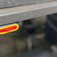 Red and yellow LED indicator light mounted on underside of gray wooden desk frame