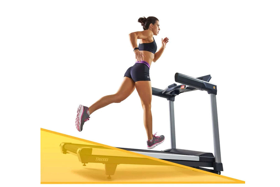 Woman running on LifeSpan TR6000i treadmill with yellow base, wearing black sports bra and shorts with purple sneakers