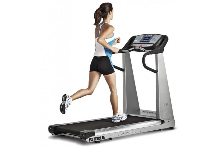 Woman running on True Z5.0 treadmill with digital display, black belt and silver frame, worn by model on white background