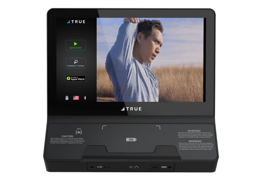 Black TRUE fitness equipment display showing workout interface with man in light blue shirt exercising outdoors on screen, fe