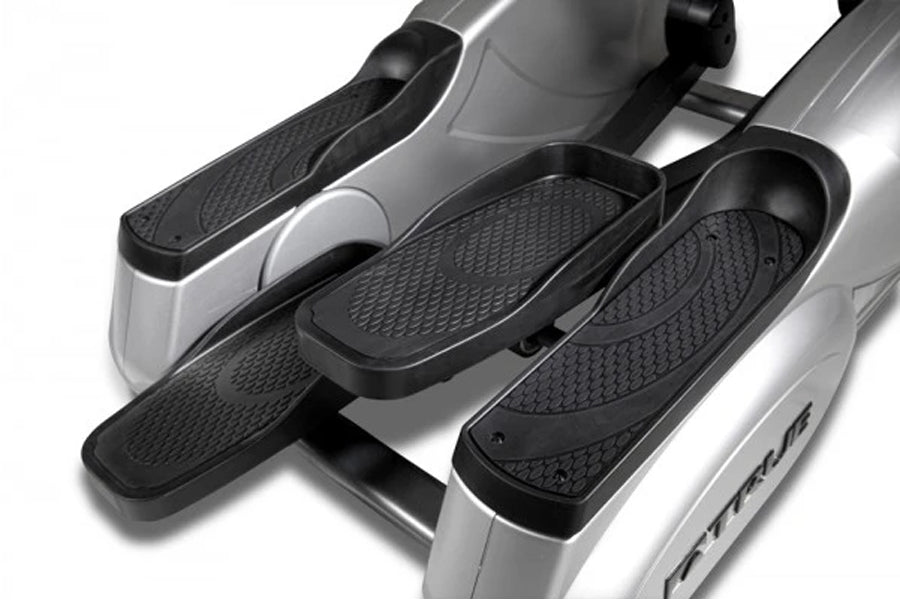 TRUE ES700 elliptical machine with silver frame and black textured foot pedals, displayed at angle on white background