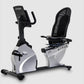TRUE ES700 recumbent exercise bike with white and black frame, mesh backrest, and digital console on gray background