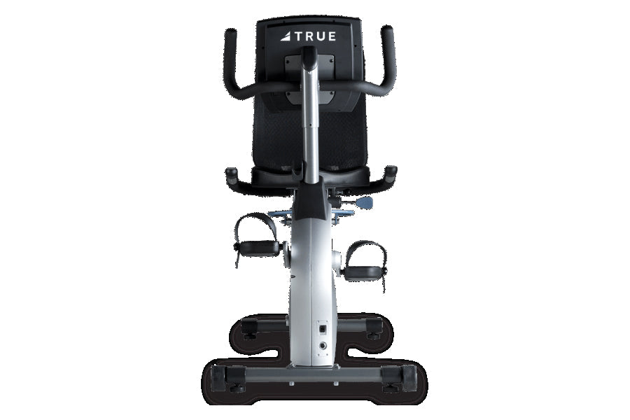 TRUE ES700 recumbent exercise bike with black seat and handlebars, silver vertical post, and black foot pedals, shown from fr