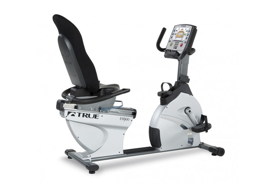 TRUE ES900 recumbent exercise bike with white frame, black seat and pedals, digital display console, on white background