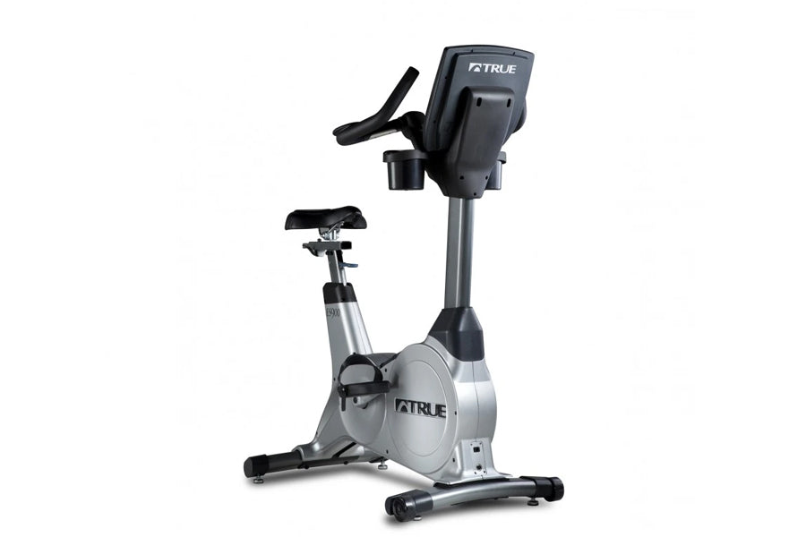 TRUE ES900 upright exercise bike with silver frame, black seat, and digital console, on white background