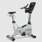 TRUE ES900 upright exercise bike with white and black frame, digital display console, and black padded seat on white backgrou