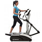 Woman in blue top and black capris using True M50 elliptical machine with white and black frame