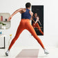 Person wearing navy tank top and orange leggings doing a lunge in front of black Studio Mirror displaying workout content on 