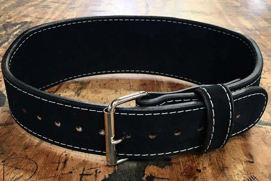 Black leather weightlifting belt with white stitching, metal buckle, and rivets, displayed flat on wooden surface