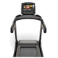 Black Matrix folding treadmill with interactive touchscreen console displaying workout content, viewed from front on white ba