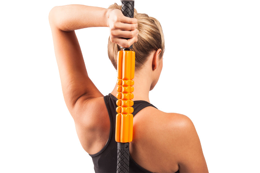 Person using orange and black foam massage roller on upper back, held vertically behind neck and shoulders
