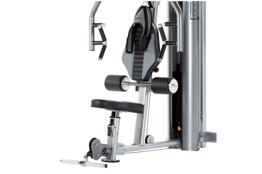 TuffStuff Apollo 7000 multi-press machine with silver frame, black seat, padded backrest, and weight stack on white backgroun