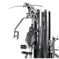 Silver and black multi-gym system with dual weight stacks, leg press station, and chest press attachment on white background