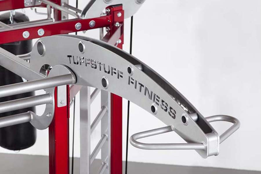 TuffStuff CT8 Compact Fitness Training System with red frame, silver handles, and "TuffStuff Fitness" branding on gray panel