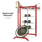 TuffStuff Medicine Ball Rebounder with red frame, circular rebound surface, storage shelves holding colored medicine balls, a