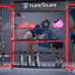TuffStuff CT8 compact fitness training system with red frame displaying dumbbells, medicine balls, weight plates, and exercis