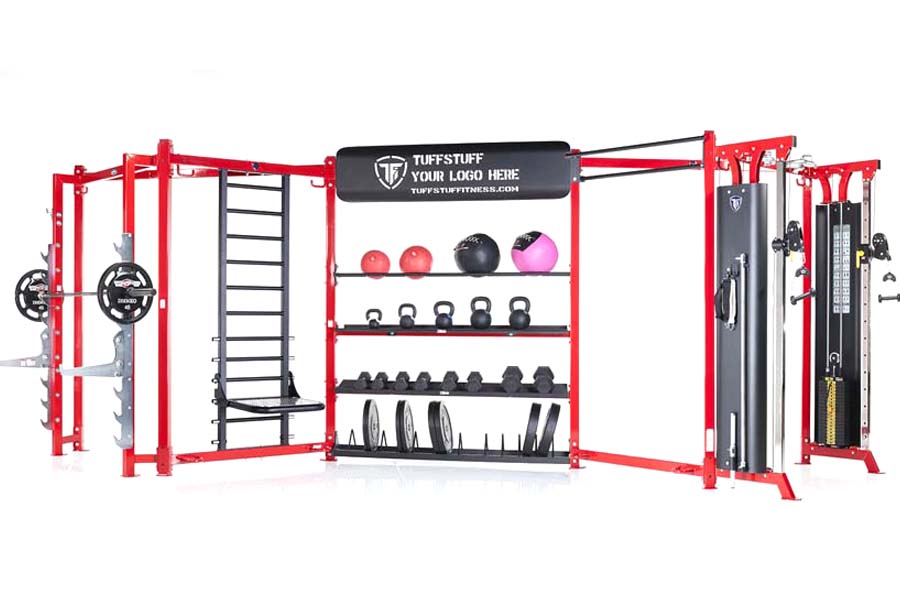 Red and black TuffStuff modular gym system with storage shelves, weight plates, kettlebells, medicine balls, and cable machin