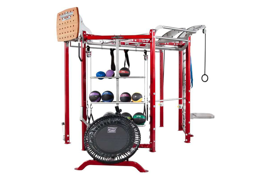 Red and gray multi-functional fitness training rig with black trampoline, storage shelves holding various medicine balls, pul