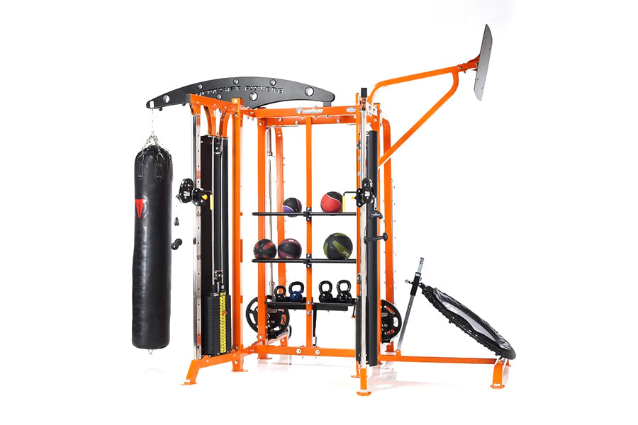 Orange and black multi-station home gym system with heavy bag, medicine balls, kettlebells, and functional training attachmen