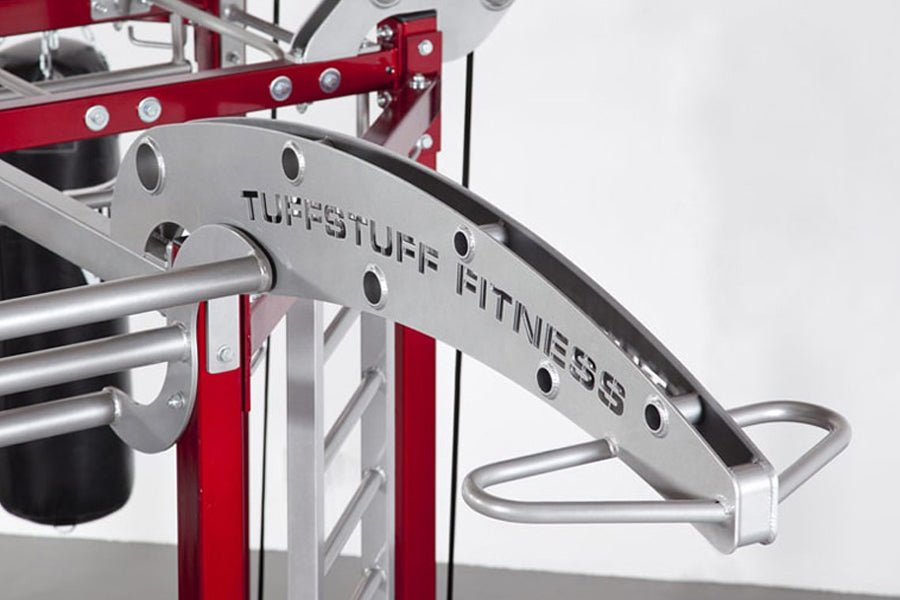 TuffStuff CT8 base fitness trainer with red and silver frame, curved pull-up bar, and metal weight stack mechanism