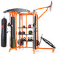 Orange and black multi-station home gym with heavy bag, medicine balls on shelves, lat pulldown, and leg press attachments on