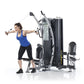 Woman using black and silver dual stack functional trainer with cable handles, demonstrating chest fly exercise on white back