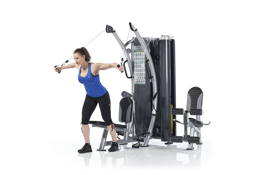 Woman using black and silver dual stack functional trainer with cable handles, demonstrating chest fly exercise on white back