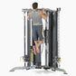 Man performing pull-up on gray and black multi-functional home gym trainer with Smith press attachment