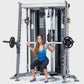 Woman performing barbell squat on silver and black multi-functional home gym trainer with weight plates attached
