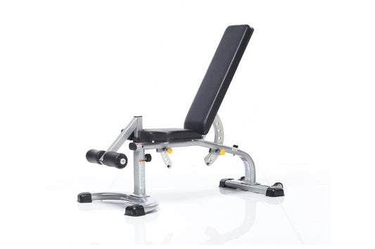 TuffStuff Evolution Deluxe Multi Purpose Bench with adjustable backrest, silver metal frame, black padding, and leg extension