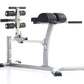 TuffStuff Evolution Glute/Ham Bench with gray metal frame, black padded seat and backrest, dumbbell rack on left side, and bl