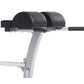 TuffStuff Evolution stationary exercise bench with black padded seat and leg extension attachment, gray steel frame on white 