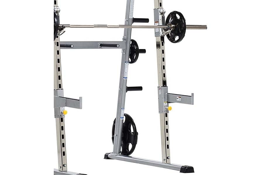 TuffStuff Evolution half cage with silver steel frame, black weight plates, and adjustable barbell rack on white background
