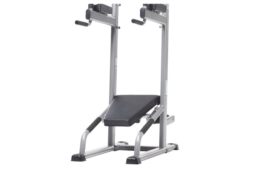 Silver and black vertical training tower with adjustable pull-up bar, dip handles, and padded seat on white background