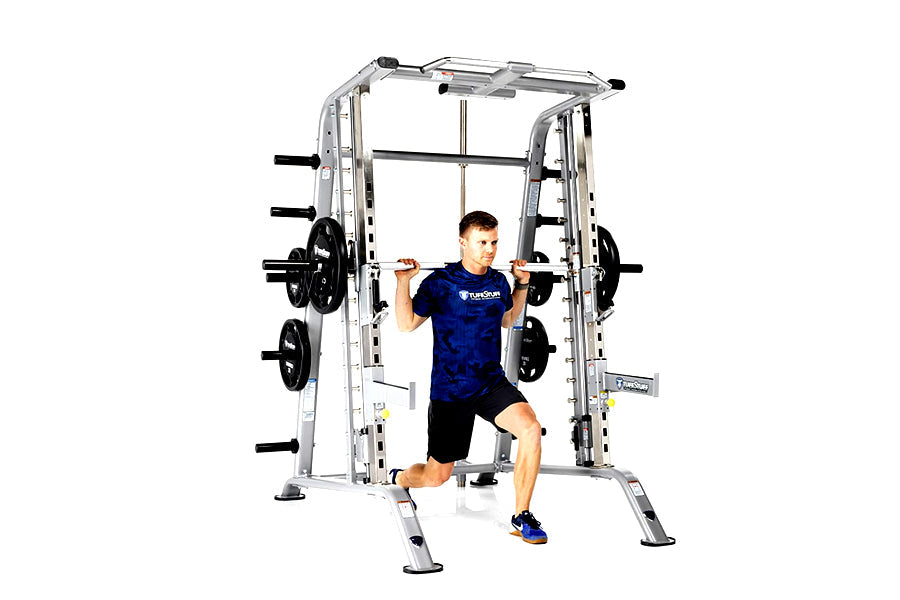 Silver and black Smith machine with half cage combo, man in blue shirt performing barbell squat exercise on white background