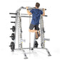 Man performing pull-up on silver and black TuffStuff Evolution Smith Machine with weight plate storage, worn by model on whit