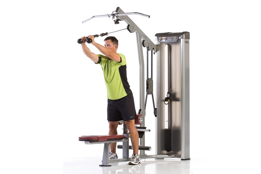 Man in neon yellow shirt using TuffStuff gray and burgundy multi-function weight machine for lat and row exercises against wh
