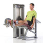 Man in lime green shirt using silver leg extension machine with burgundy seat and foot pads